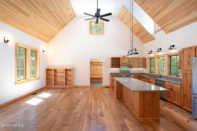 a open kitchen with stainless steel appliances granite countertop a stove and cabinets with wooden floor