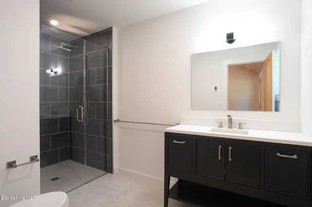 a bathroom with a shower sink and mirror