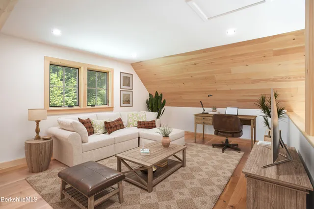 a living room with furniture wooden floor and a large window