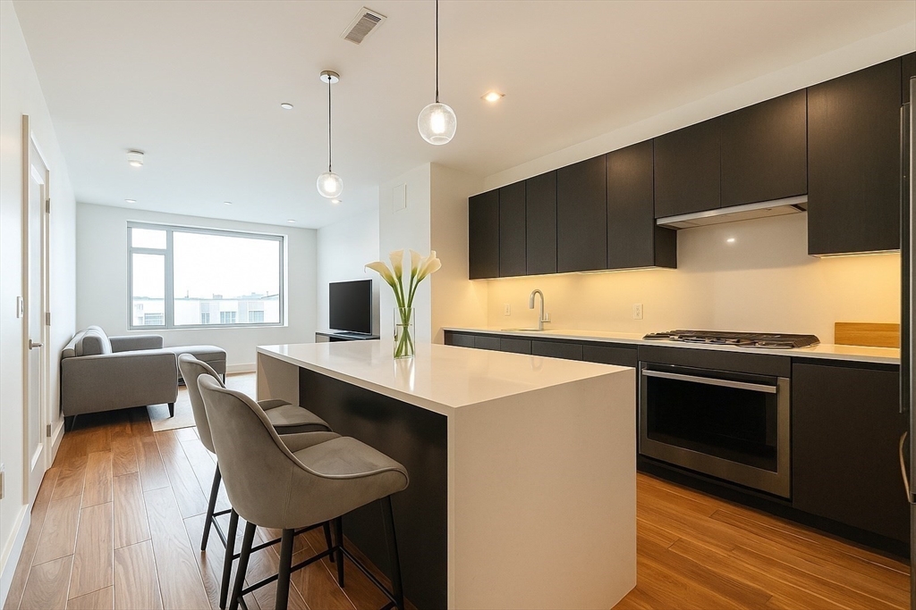 99 Sumner Street, Unit 606 Boston, MA 02128 - Photo 2 of 22 a kitchen with a sink cabinets and wooden floor