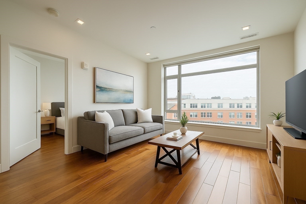 99 Sumner Street, Unit 606 Boston, MA 02128 - Photo 5 of 22 a living room with furniture and a flat screen tv