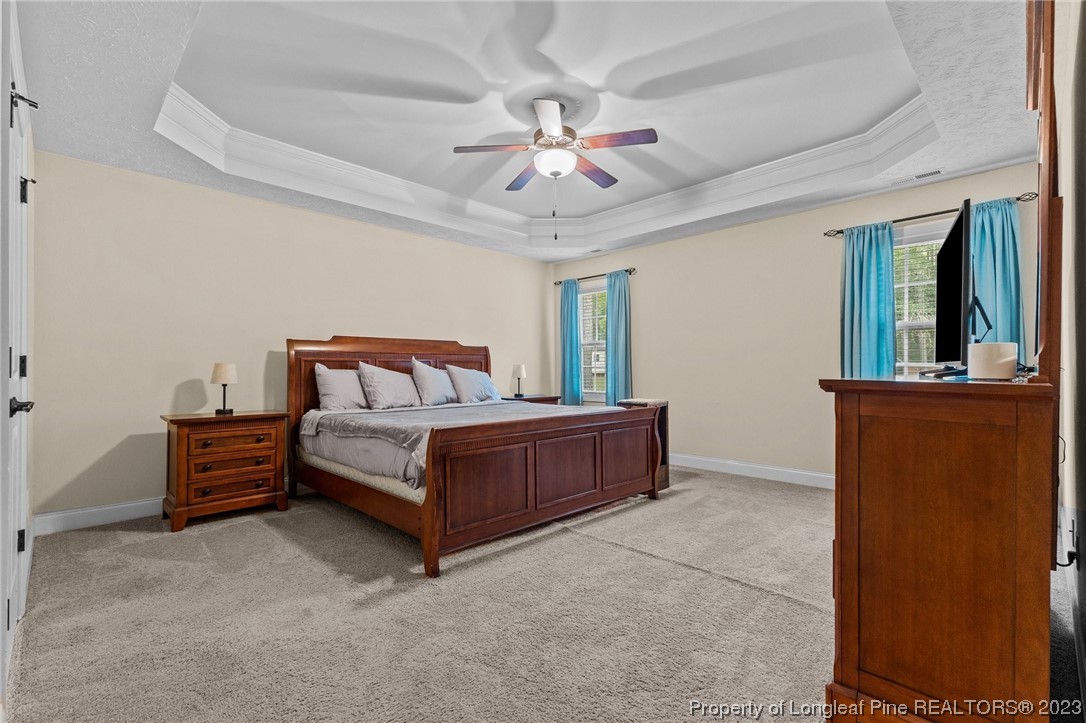 155 Dicks Hill Road Carthage, NC 28327 - Photo 28 of 47 a bedroom with a bed and a chandelier