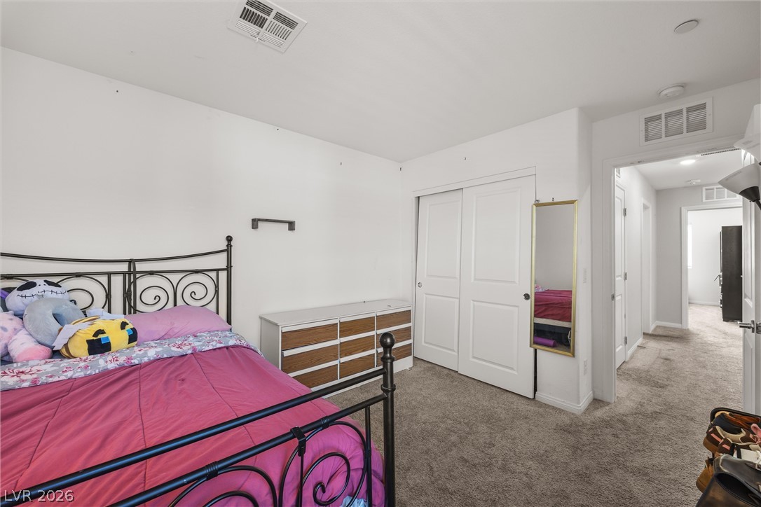 12240 Golden Wreath Road, Unit 2 Las Vegas, NV 89183 - Photo 11 of 29 Plush wall-to-wall carpeting and neutral walls define this inviting bedroom space.