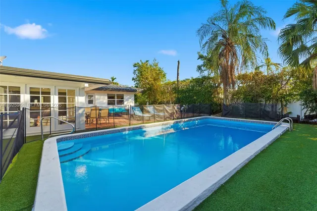 a view of an house with swimming pool and sitting area