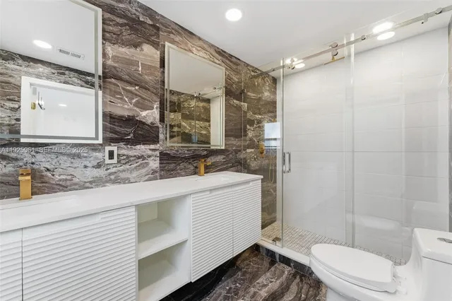 a bathroom with a sink a toilet and shower