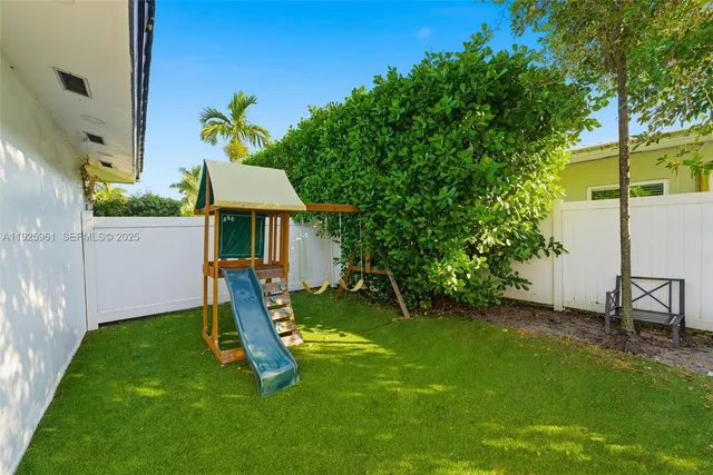 a view of a backyard with a slide and a table