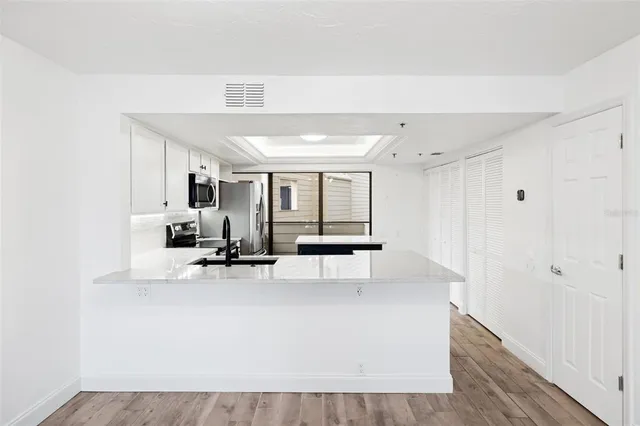 a kitchen with stainless steel appliances granite countertop a refrigerator sink and stove