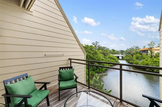 a balcony with table and chairs with wooden floor and stairs