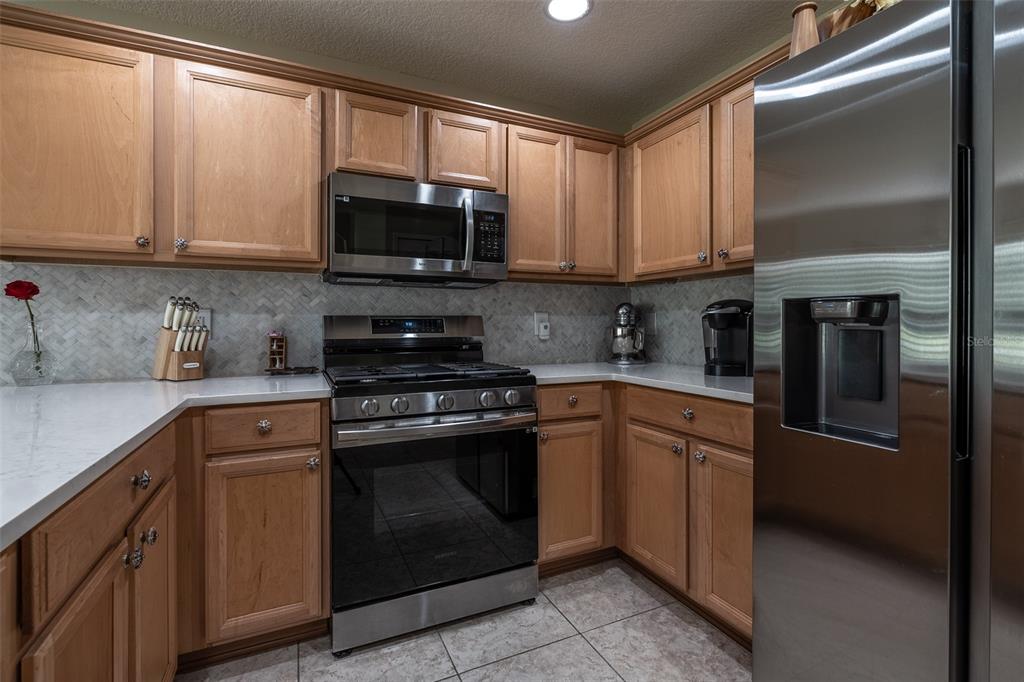 16023 Southwest 14th Avenue Road Ocala, FL 34473 - Photo 13 of 57 a kitchen with stainless steel appliances granite countertop a stove a sink and a microwave