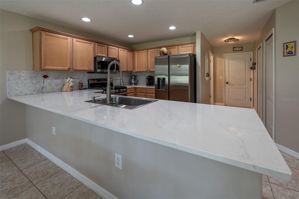 16023 Southwest 14th Avenue Road Ocala, FL 34473 - Photo 18 of 57 a kitchen with stainless steel appliances a refrigerator sink microwave and cabinets