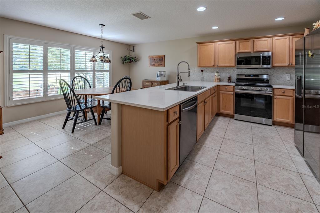 16023 Southwest 14th Avenue Road Ocala, FL 34473 - Photo 19 of 57 a kitchen with stainless steel appliances granite countertop a stove top oven a sink a counter top space appliances and cabinets
