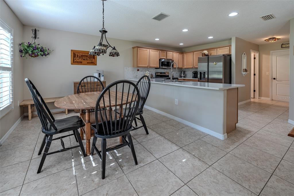 16023 Southwest 14th Avenue Road Ocala, FL 34473 - Photo 20 of 57 a kitchen with stainless steel appliances kitchen island granite countertop a dining table chairs and granite counter tops
