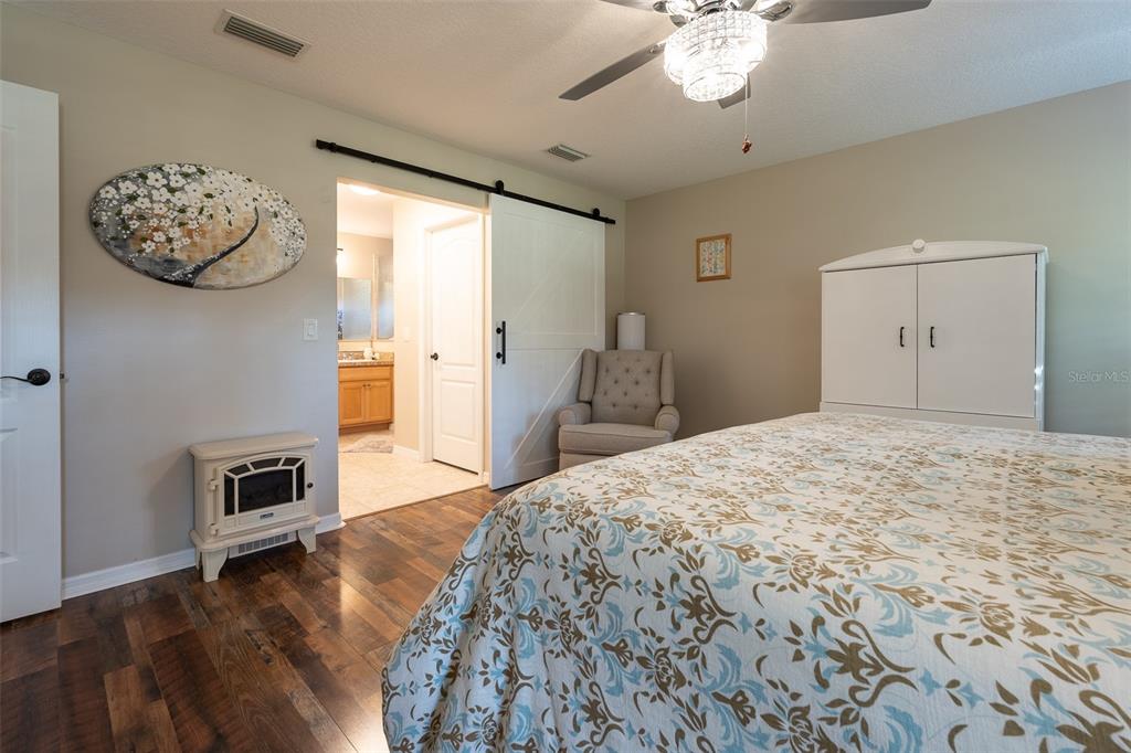 16023 Southwest 14th Avenue Road Ocala, FL 34473 - Photo 26 of 57 a bedroom with a bed and a chandelier