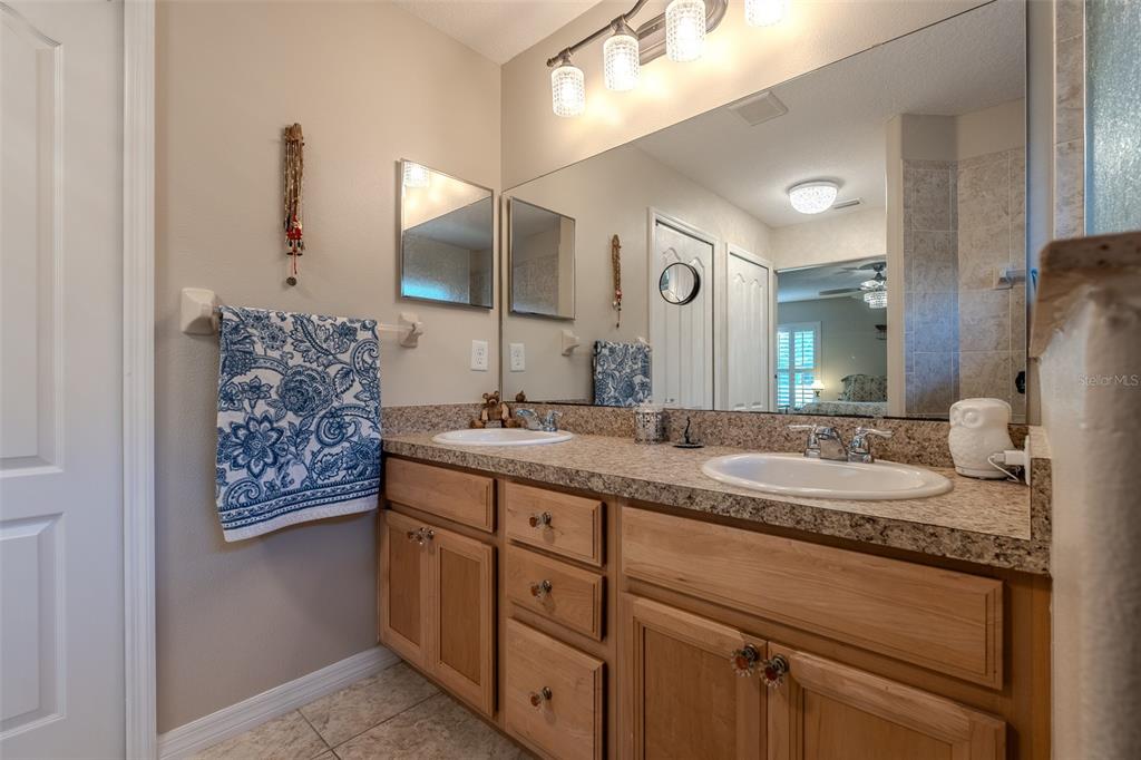 16023 Southwest 14th Avenue Road Ocala, FL 34473 - Photo 30 of 57 a bathroom with a granite countertop sink and a mirror