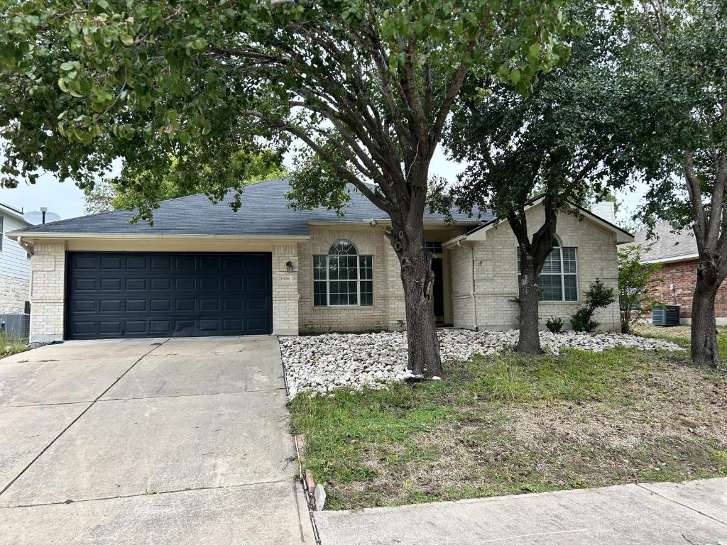 Ranch-style house with concrete driveway, an attached garage, and brick siding