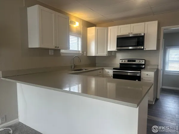 a kitchen with granite countertop a sink and a stove top oven