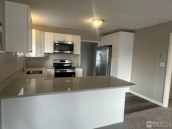 a kitchen with granite countertop a refrigerator and a stove top oven