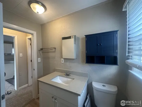 a bathroom with a toilet sink vanity and mirror