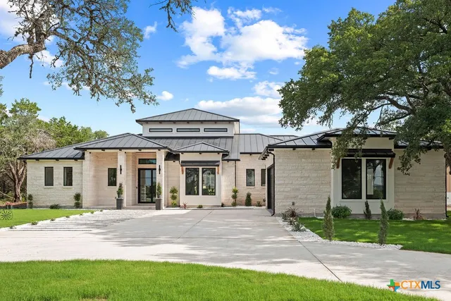 a front view of a house with a garden and plants