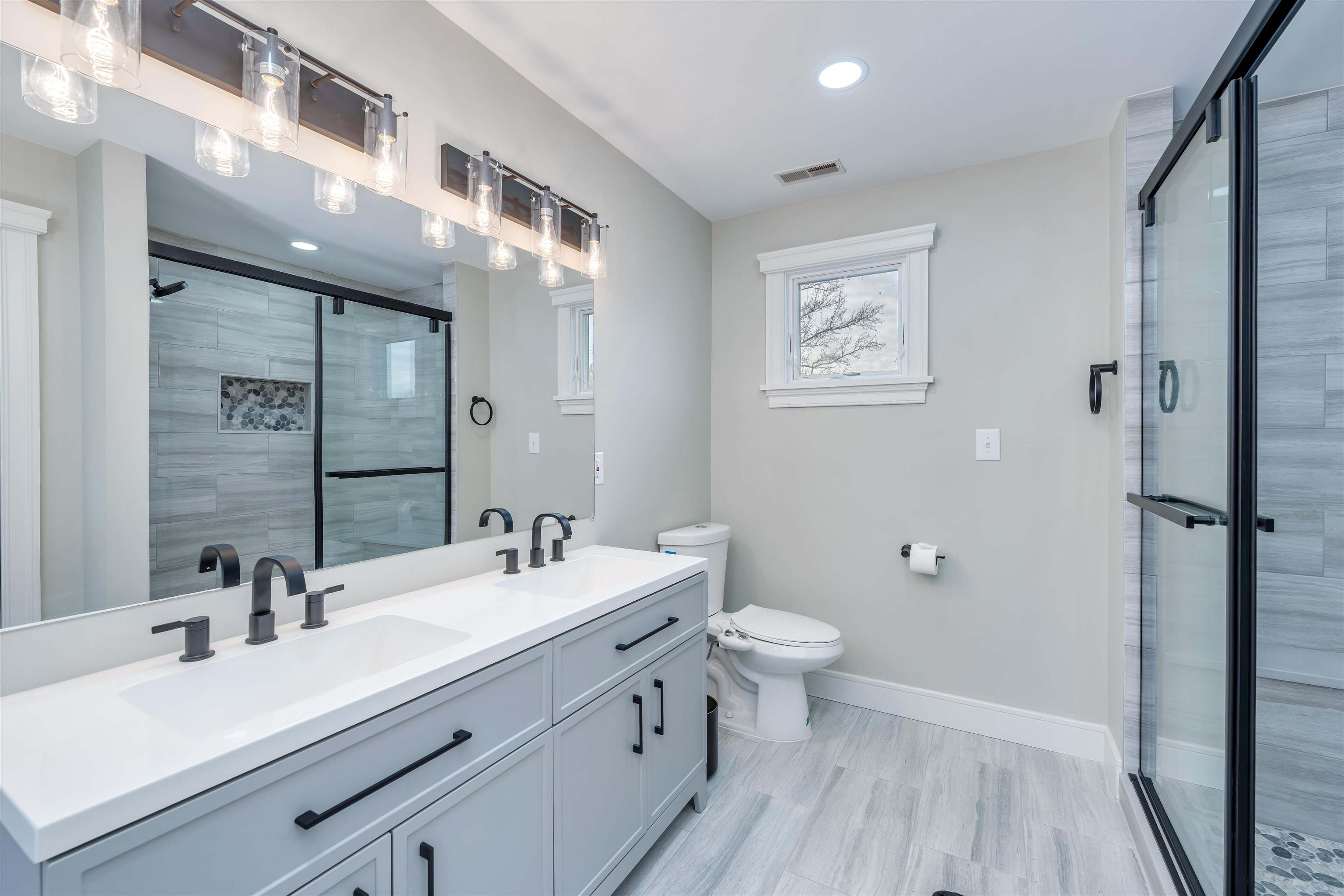 667 Dias Creek Road Cape May Court House, NJ 08210 - Photo 28 of 43 a bathroom with a double vanity sink toilet and a mirror