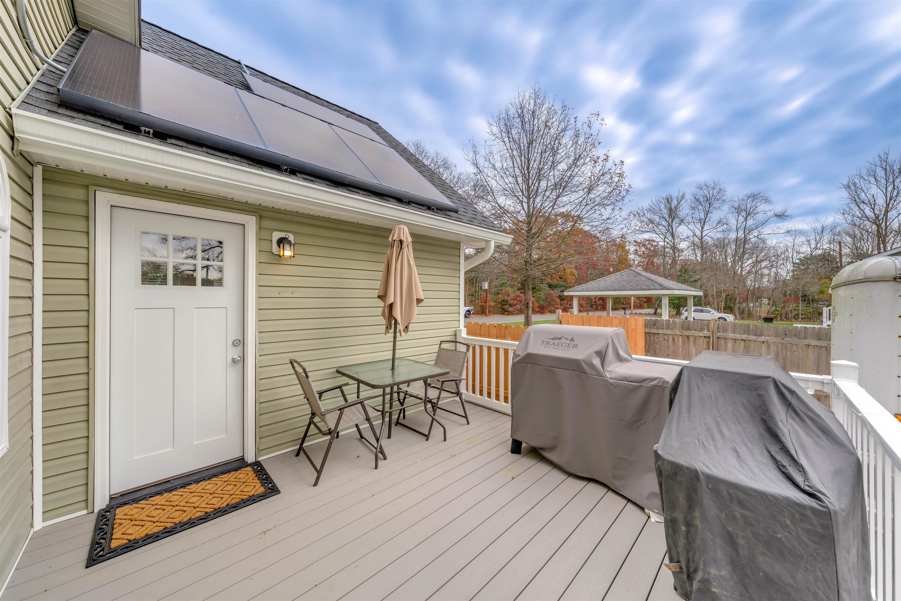 667 Dias Creek Road Cape May Court House, NJ 08210 - Photo 35 of 43 a view of a patio with couches and table and chairs with wooden floor and fence