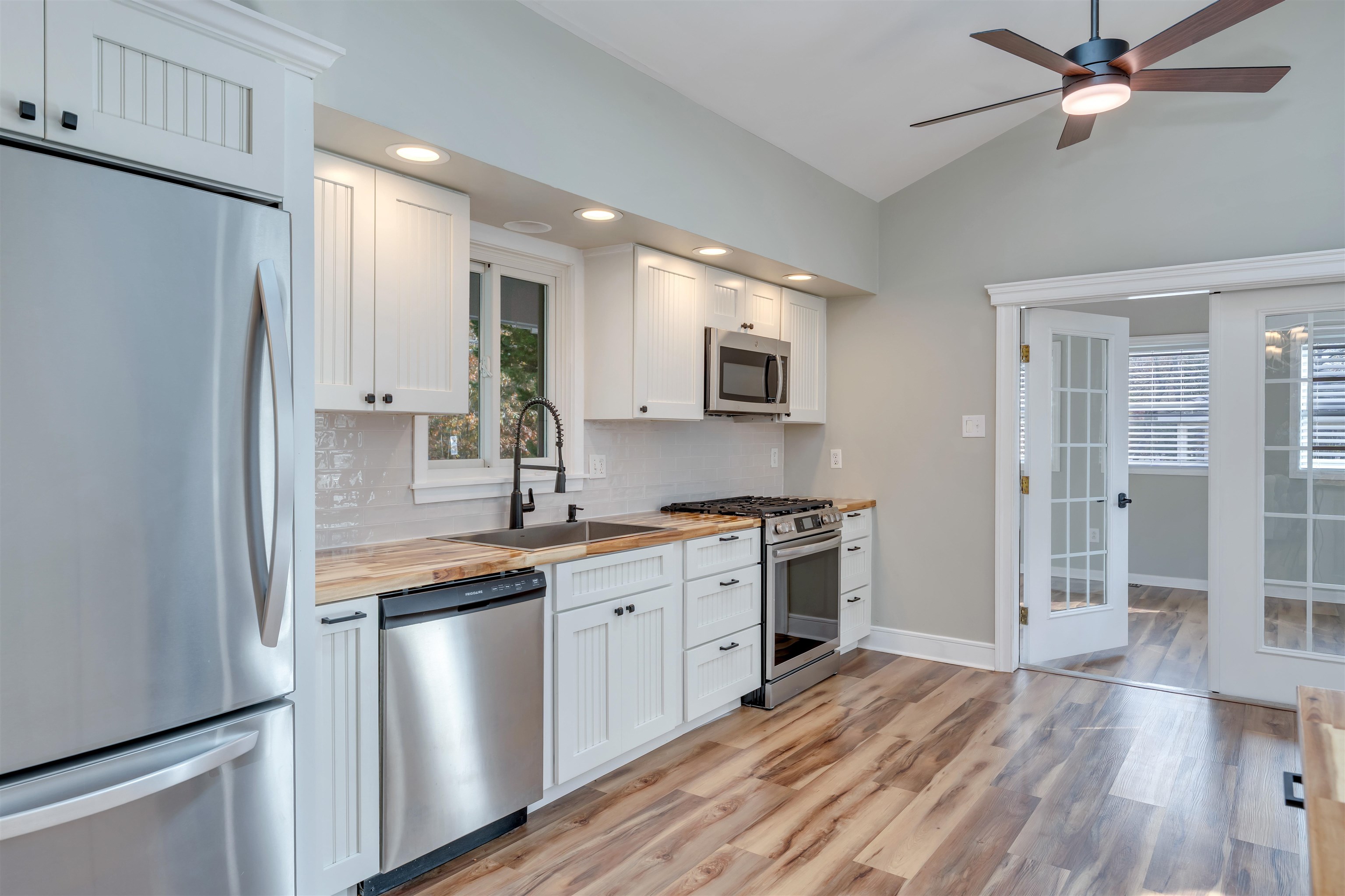 667 Dias Creek Road Cape May Court House, NJ 08210 - Photo 9 of 43 a kitchen with stainless steel appliances granite countertop a refrigerator a stove a sink and white cabinets with wooden floor