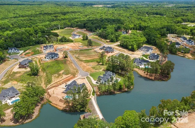 an aerial view of a house with a yard and lake view