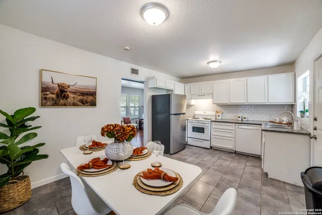 a kitchen with stainless steel appliances a dining table and chairs