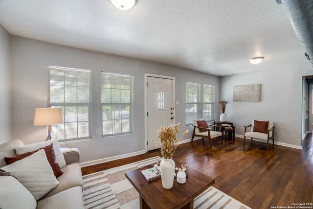 a living room with furniture and wooden floor