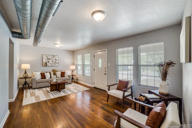 a living room with furniture and wooden floor