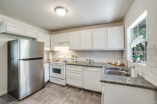 a kitchen with appliances a sink and a window