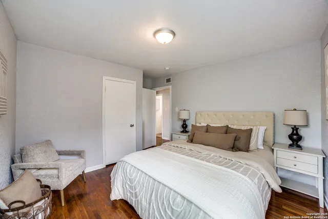 a bedroom with a bed and wooden floor