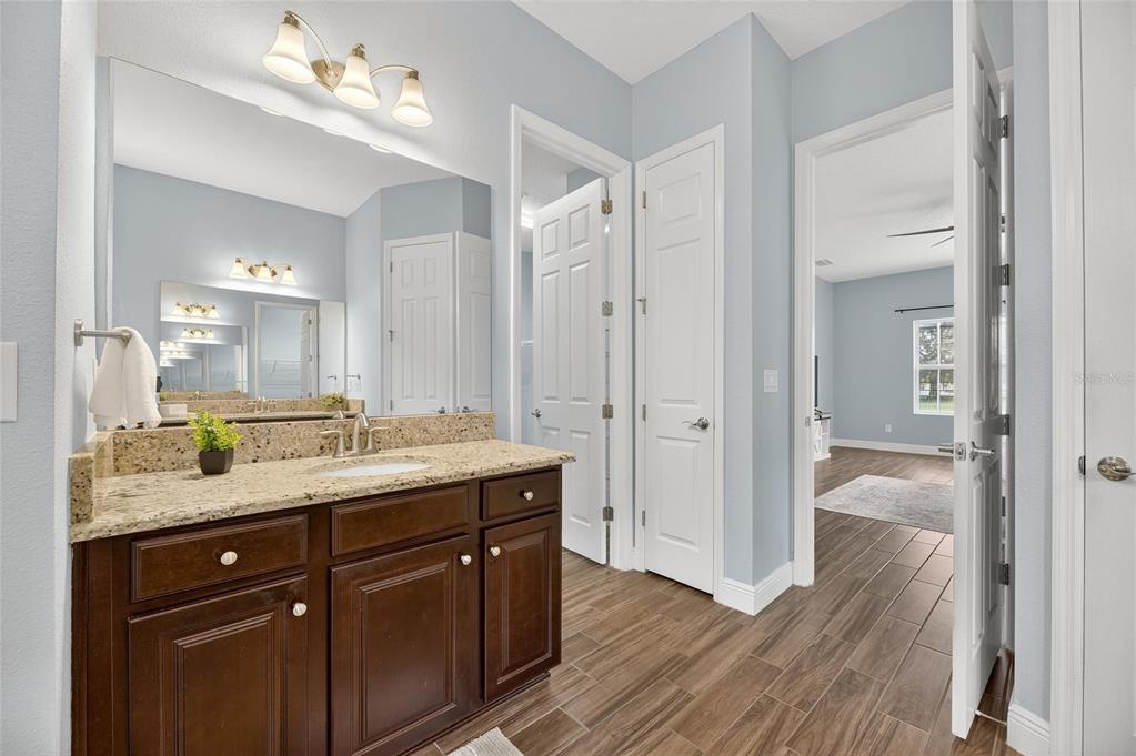 7223 Bowspirit Place Apollo Beach, FL 33572 - Photo 48 of 92 a bathroom with a granite countertop sink a mirror and a shower