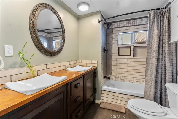 a bathroom with a granite countertop sink mirror toilet and bathtub