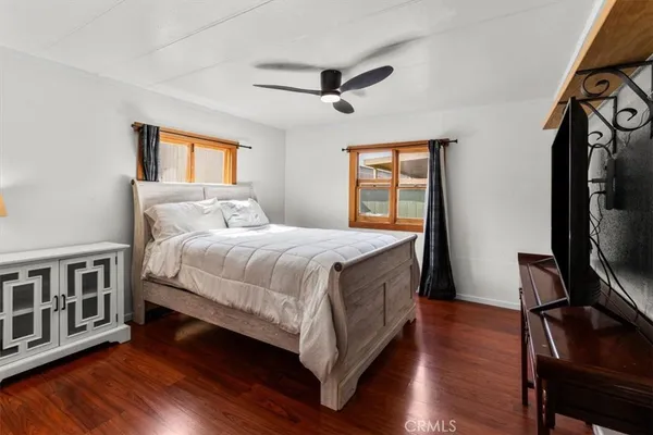 a bedroom with a bed wooden floor and window