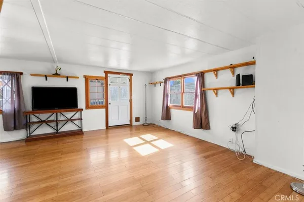 a view of a livingroom with wooden floor and a flat screen tv