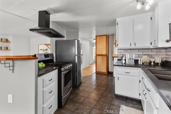 a kitchen with stainless steel appliances granite countertop a refrigerator stove and sink