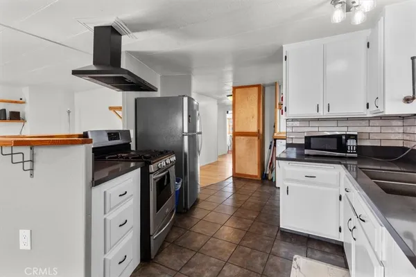 a kitchen with stainless steel appliances granite countertop a refrigerator a stove and a sink