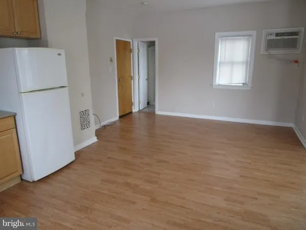 a view of an empty room with closet and a window