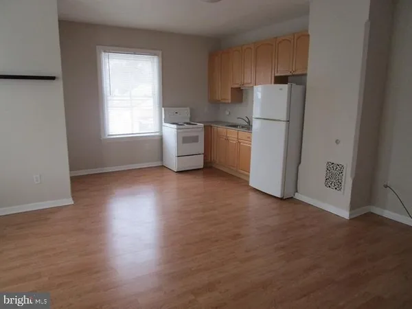 a kitchen with a refrigerator a sink and a stove top oven