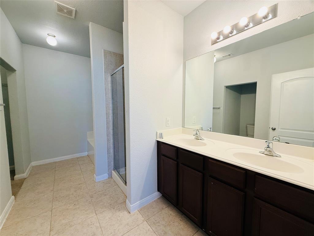 223 Magnolia Drive Princeton, TX 75407 - Photo 11 of 29 a bathroom with a double vanity sink and mirror