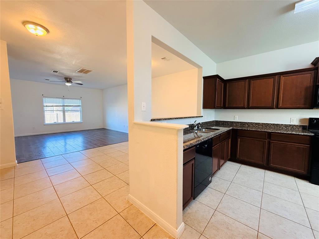 223 Magnolia Drive Princeton, TX 75407 - Photo 4 of 29 a kitchen with granite countertop a stove a sink and a refrigerator