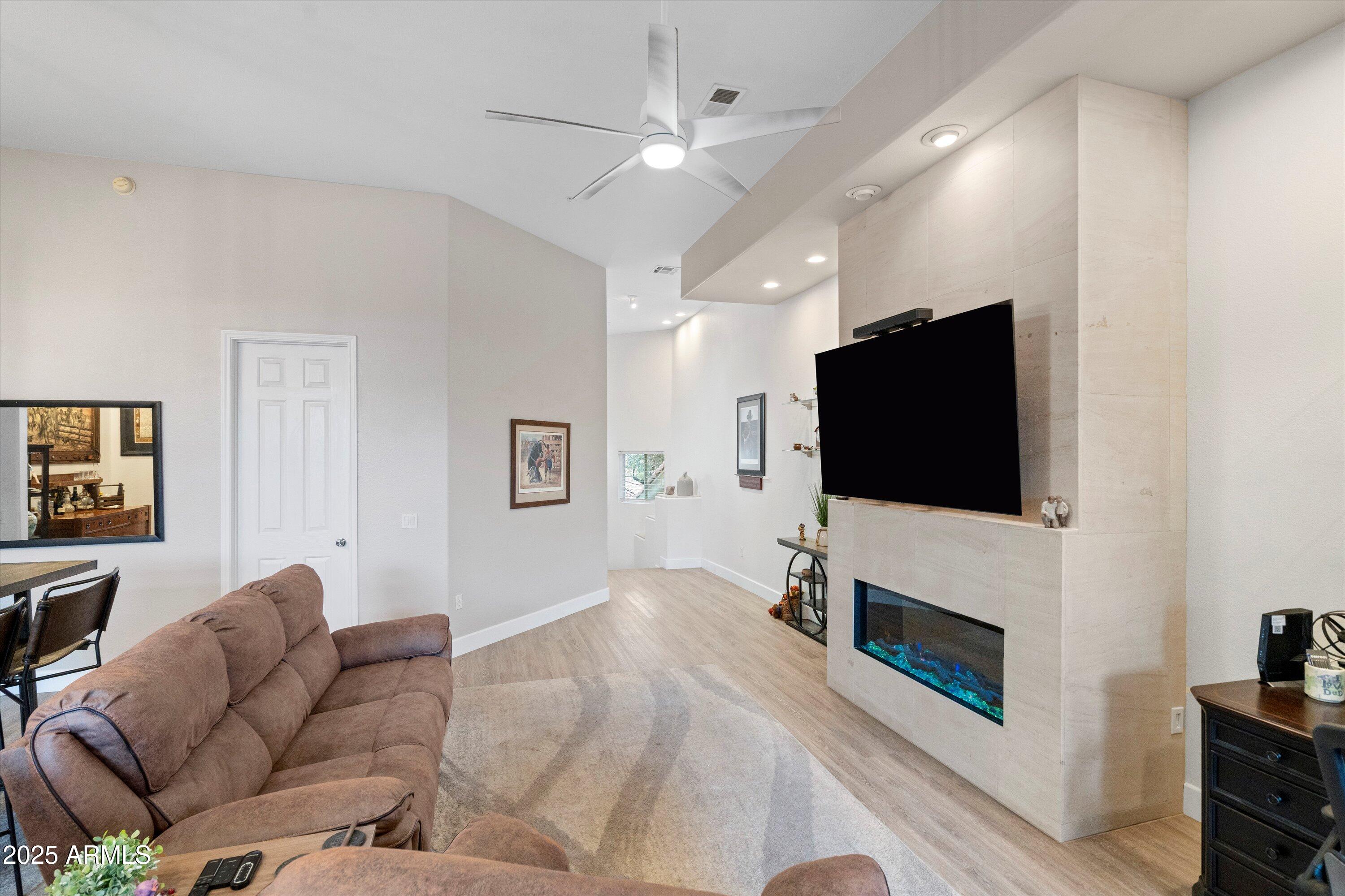 8245 East Bell Road, Unit 250 Scottsdale, AZ 85260 - Photo 9 of 48 a living room with fireplace furniture and a flat screen tv