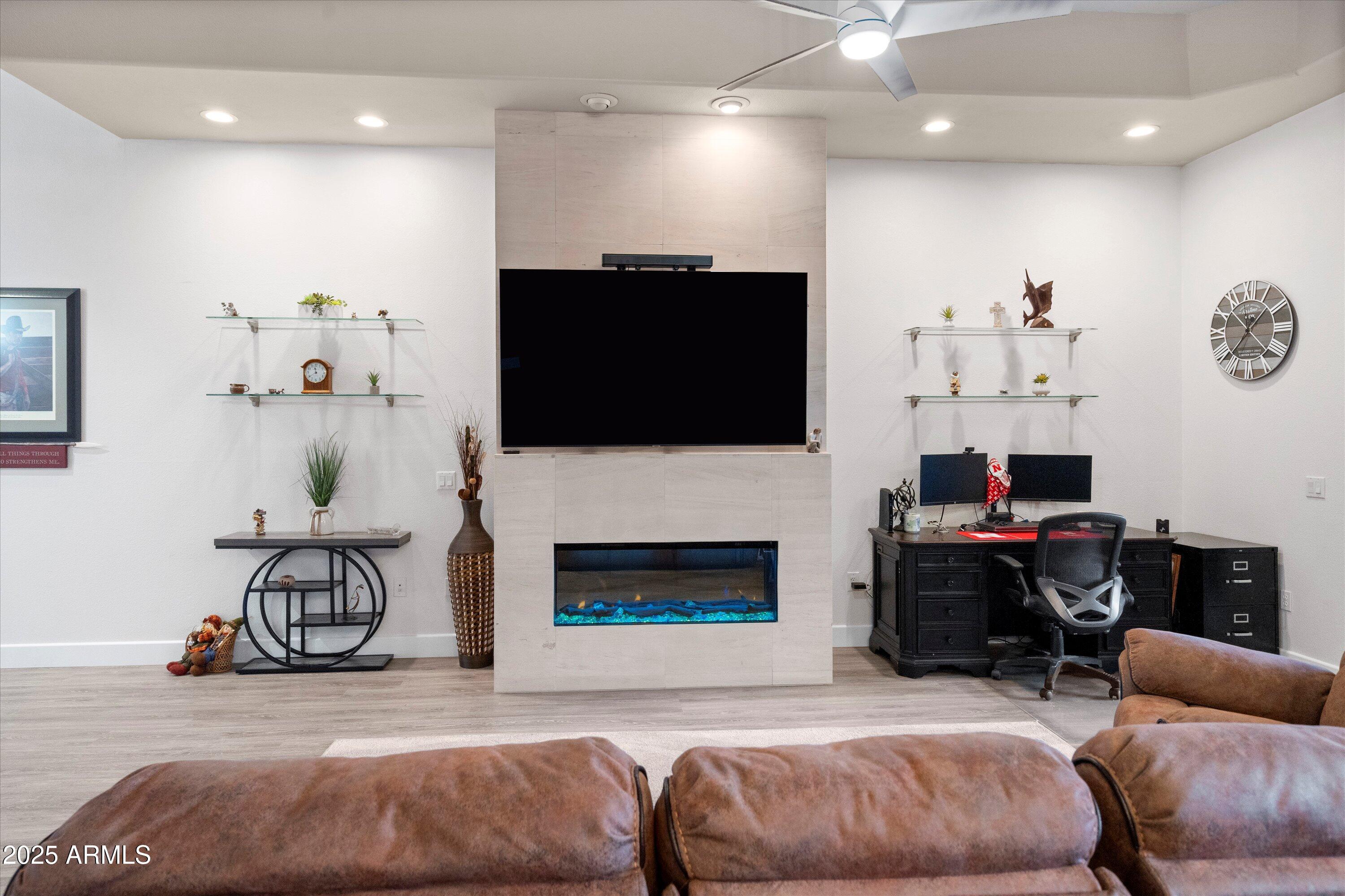 8245 East Bell Road, Unit 250 Scottsdale, AZ 85260 - Photo 11 of 48 a living room with furniture a flat screen tv and a fireplace