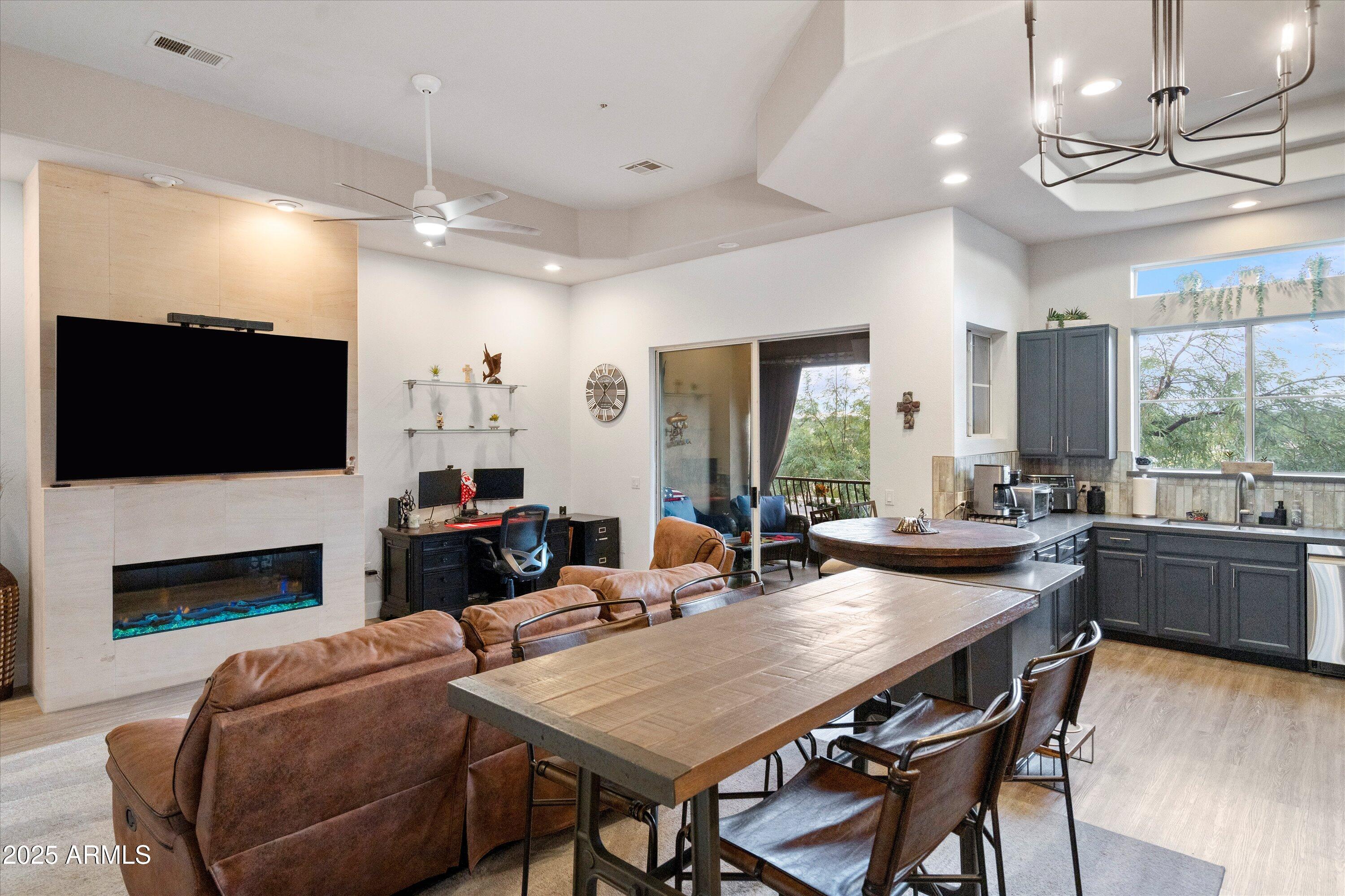 8245 East Bell Road, Unit 250 Scottsdale, AZ 85260 - Photo 14 of 48 a view of a dining room with furniture a fireplace and wooden floor