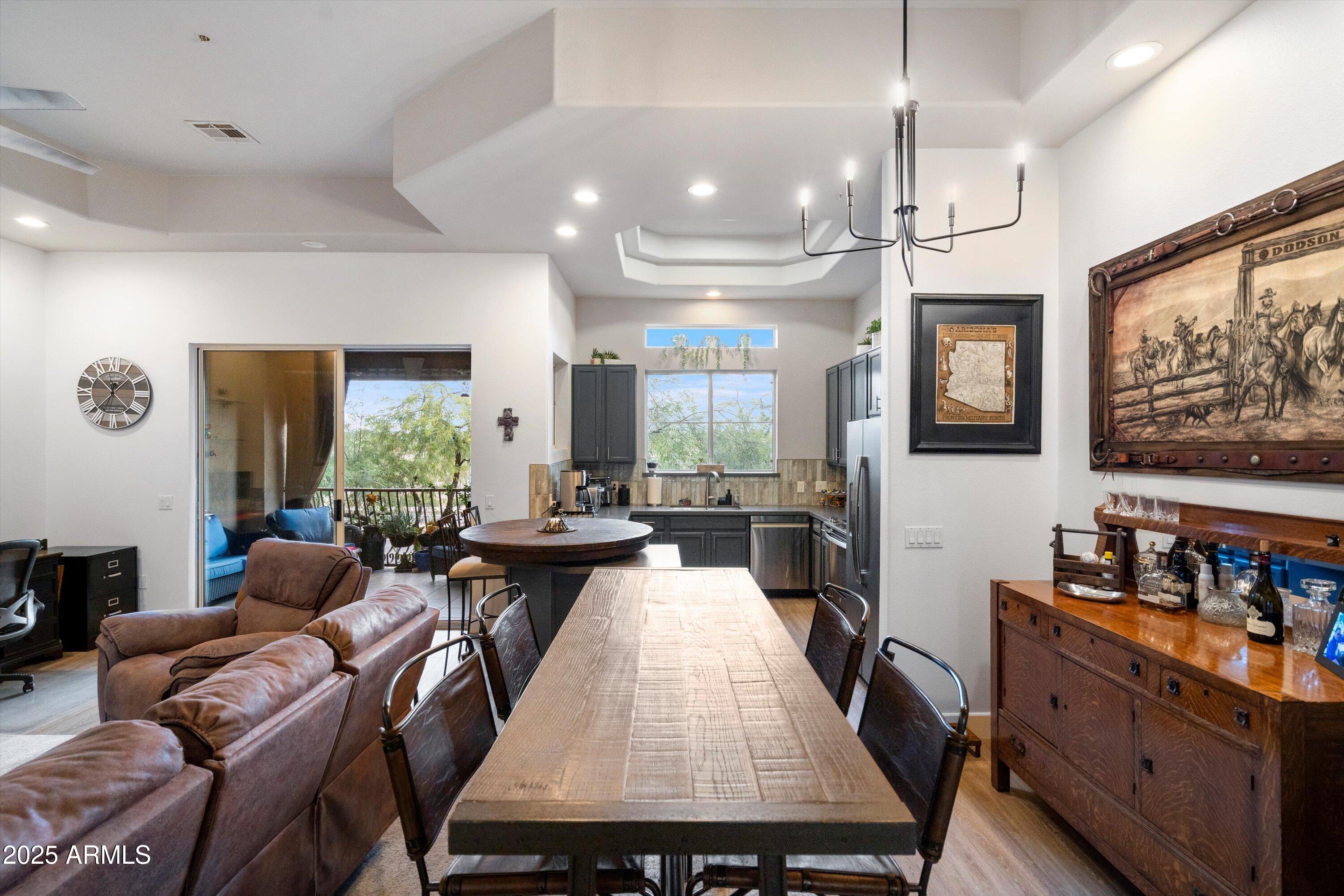8245 East Bell Road, Unit 250 Scottsdale, AZ 85260 - Photo 15 of 48 a view of a dining room with furniture a kitchen and chandelier