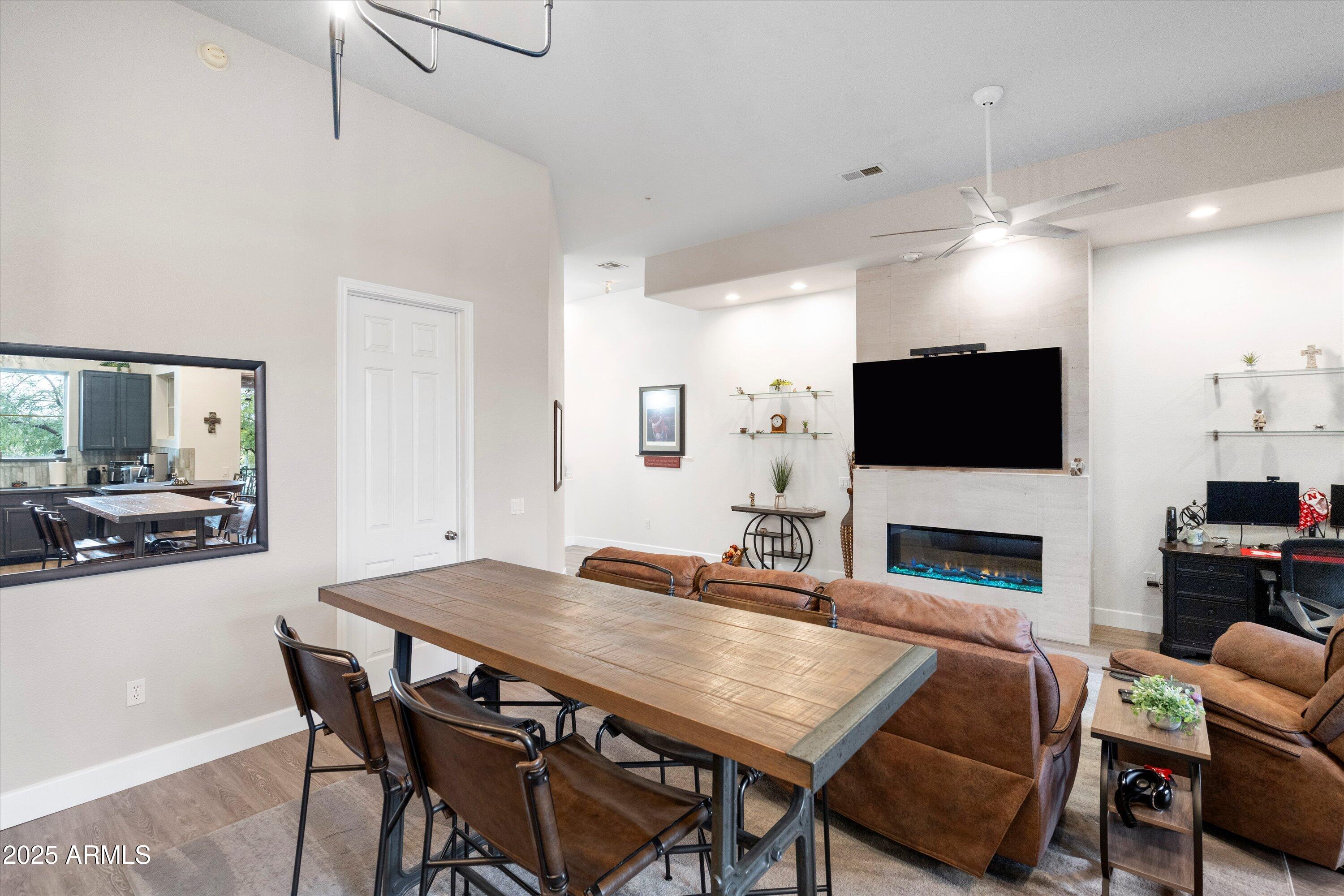 8245 East Bell Road, Unit 250 Scottsdale, AZ 85260 - Photo 17 of 48 a view of a dining room with furniture a fireplace and wooden floor