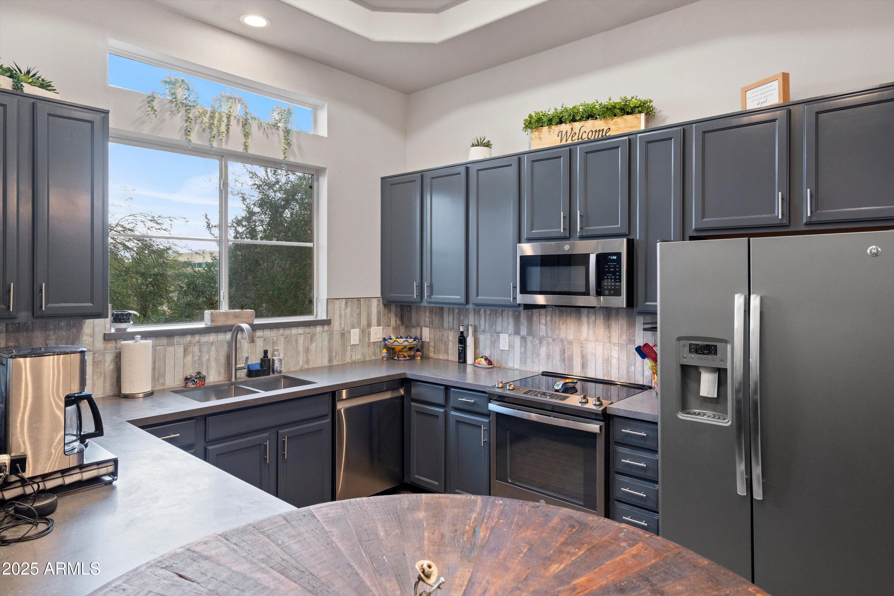 8245 East Bell Road, Unit 250 Scottsdale, AZ 85260 - Photo 21 of 48 a kitchen with a sink a stove and a refrigerator