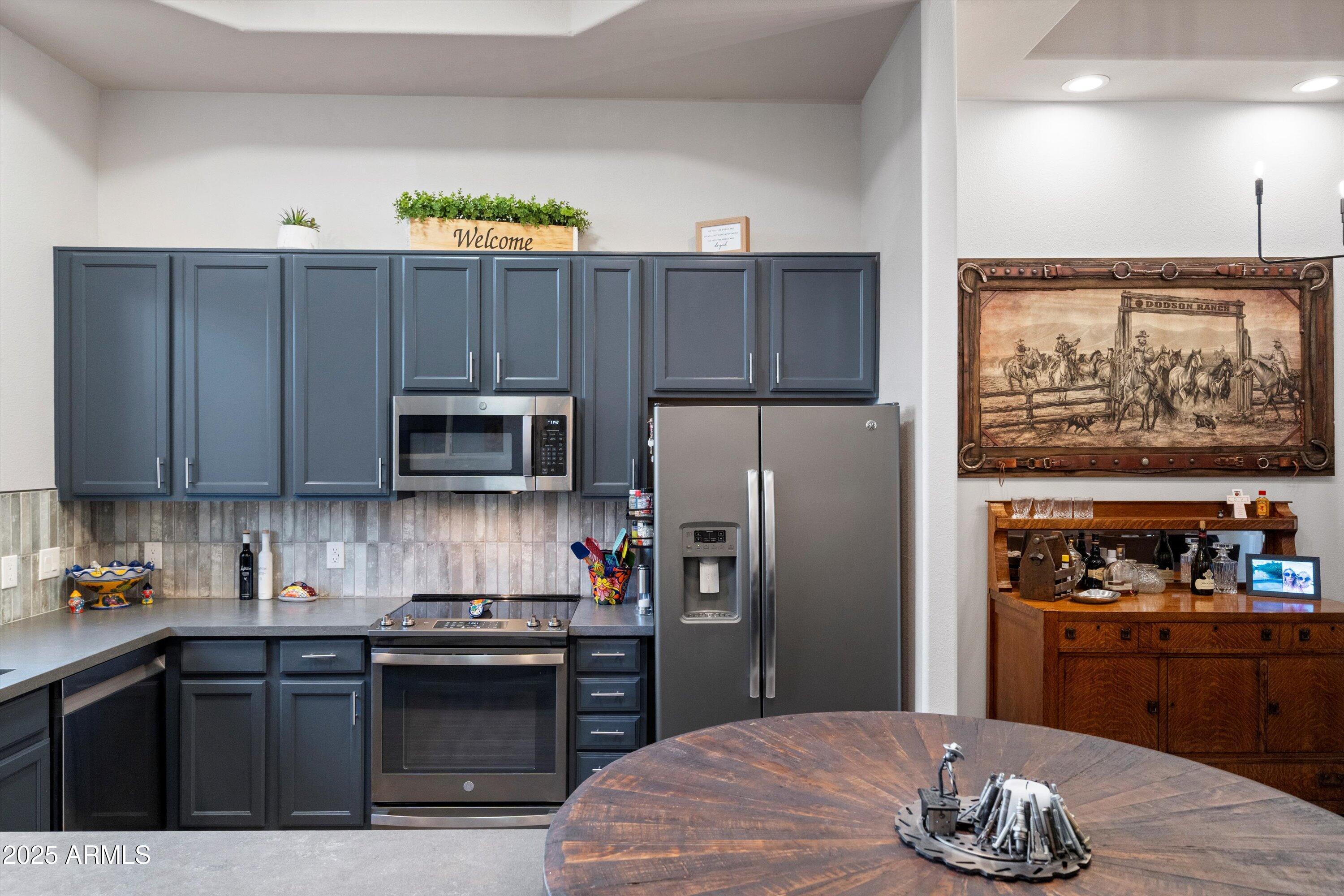 8245 East Bell Road, Unit 250 Scottsdale, AZ 85260 - Photo 22 of 48 a kitchen with granite countertop wooden cabinets a refrigerator and a stove top oven
