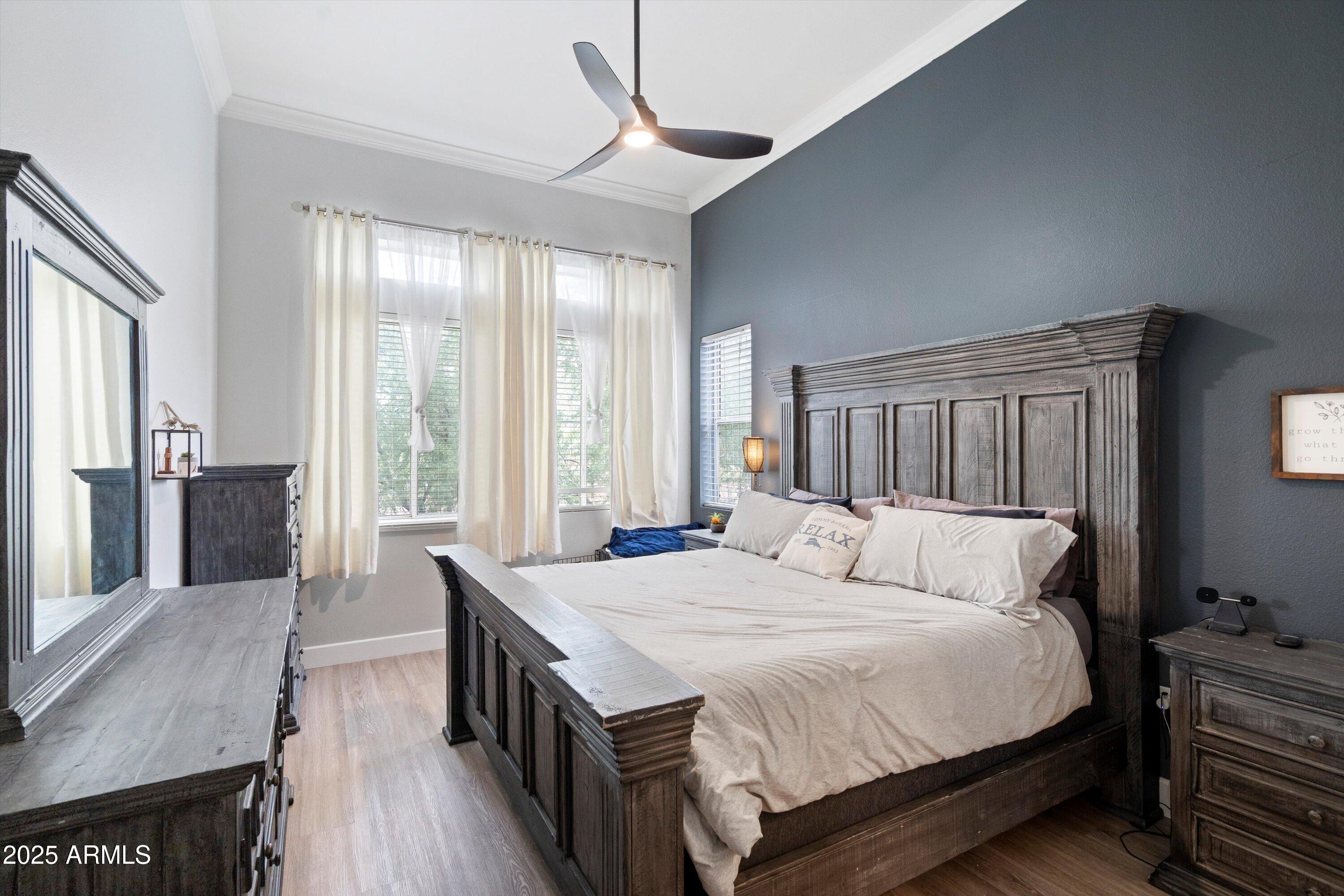 8245 East Bell Road, Unit 250 Scottsdale, AZ 85260 - Photo 25 of 48 a bedroom with a bed a large window and wooden floor